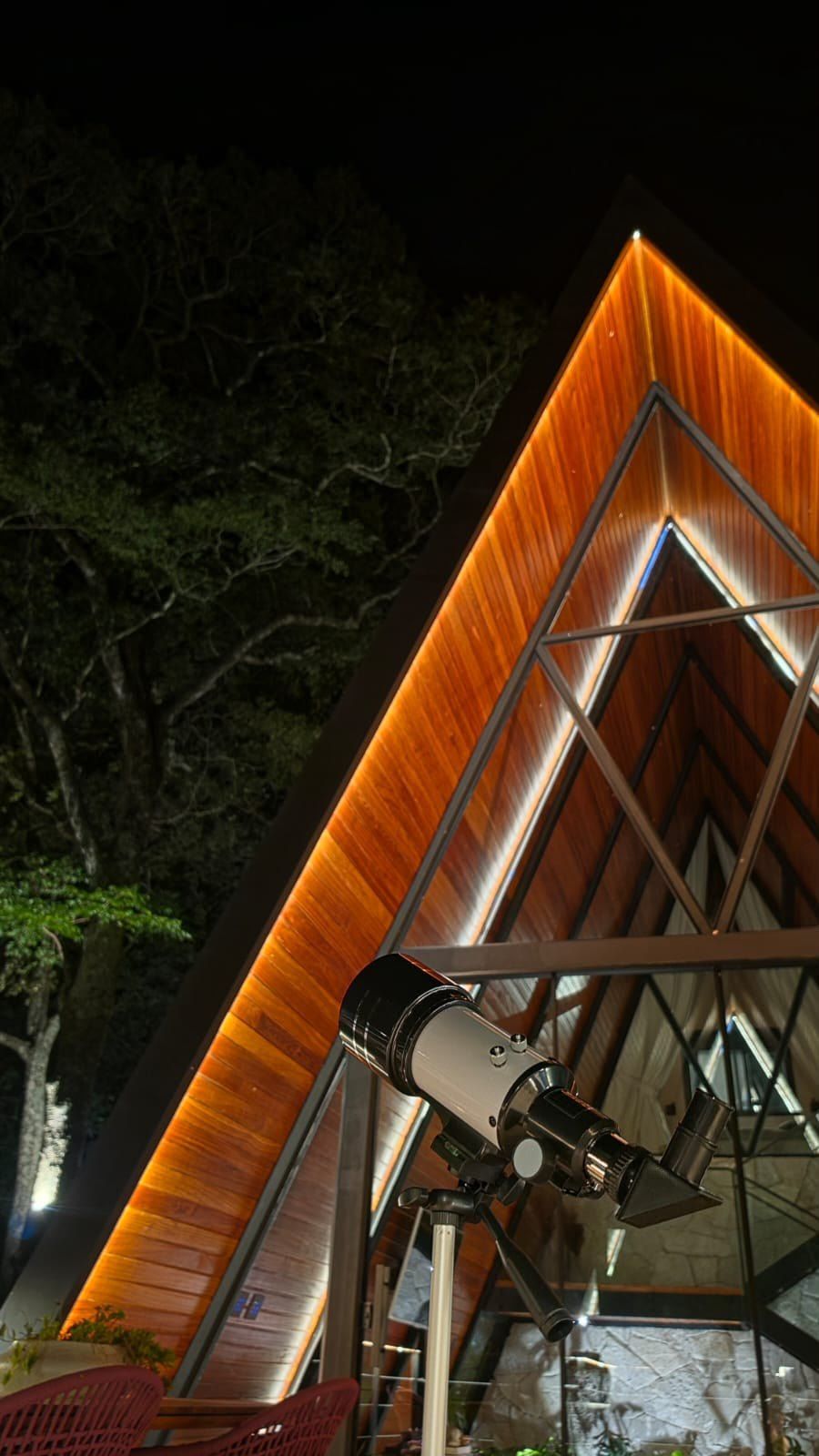 Telescópio no deck ao lado da fachada em A iluminada à noite